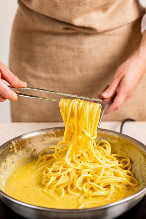 Toss the pasta in carbonara sauce